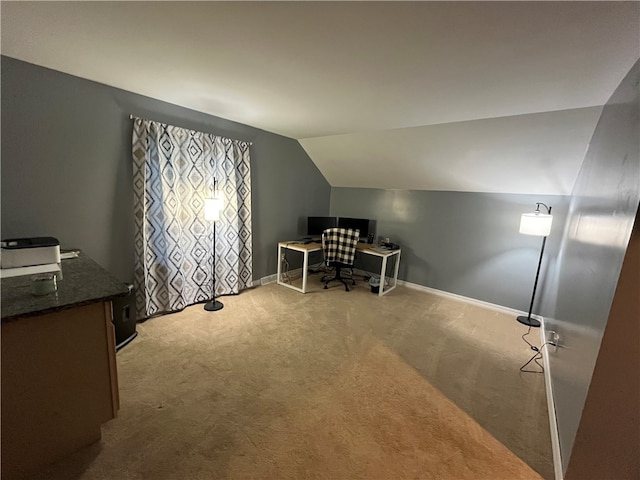 carpeted home office with lofted ceiling