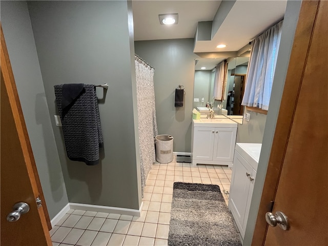 bathroom with tile patterned flooring, vanity, and walk in shower