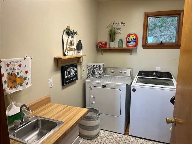 clothes washing area with washing machine and clothes dryer and sink