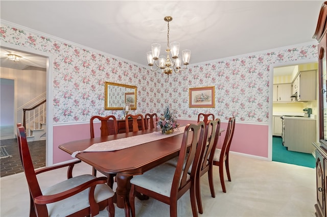 dining room featuring ornamental molding, a notable chandelier, and light colored carpet