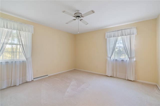 empty room featuring light carpet, plenty of natural light, a baseboard radiator, and ceiling fan