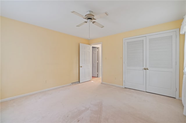 unfurnished bedroom with a closet, ceiling fan, and light carpet