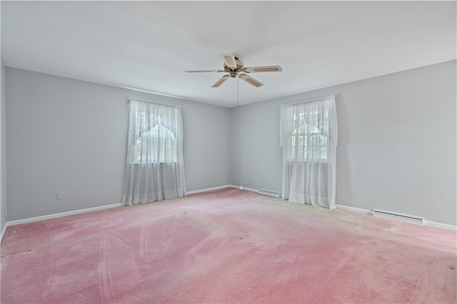 carpeted spare room featuring ceiling fan, plenty of natural light, and a baseboard radiator