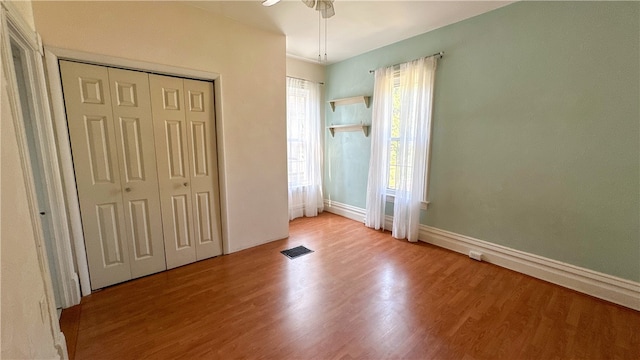 unfurnished bedroom with ceiling fan, a closet, and light hardwood / wood-style floors