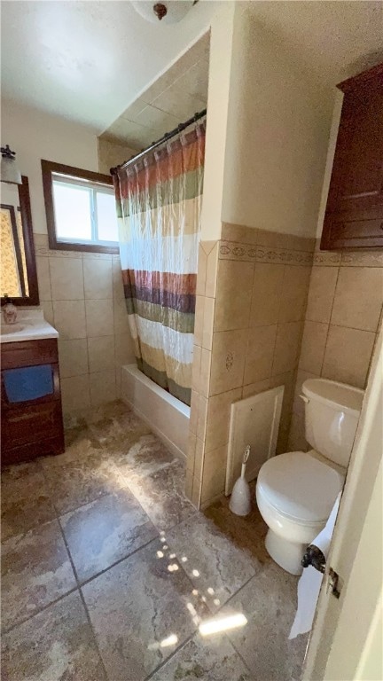 full bathroom featuring vanity, toilet, shower / bathtub combination with curtain, and tile walls