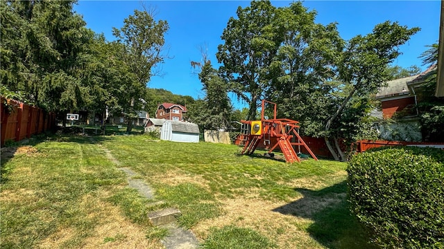 view of yard featuring a storage unit and a playground