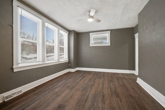 unfurnished room with ceiling fan and dark hardwood / wood-style floors