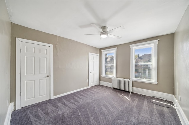 carpeted spare room with ceiling fan and radiator