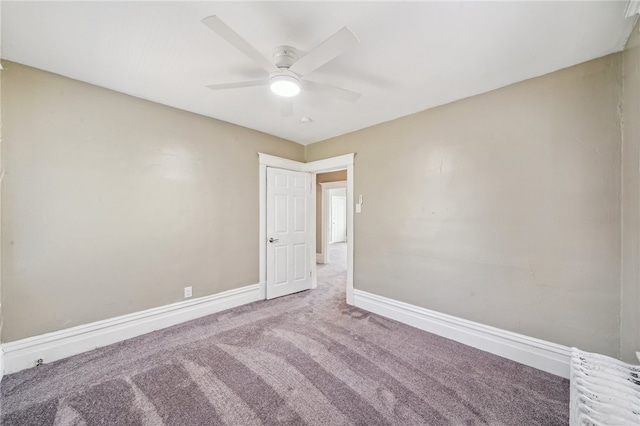 carpeted spare room featuring ceiling fan