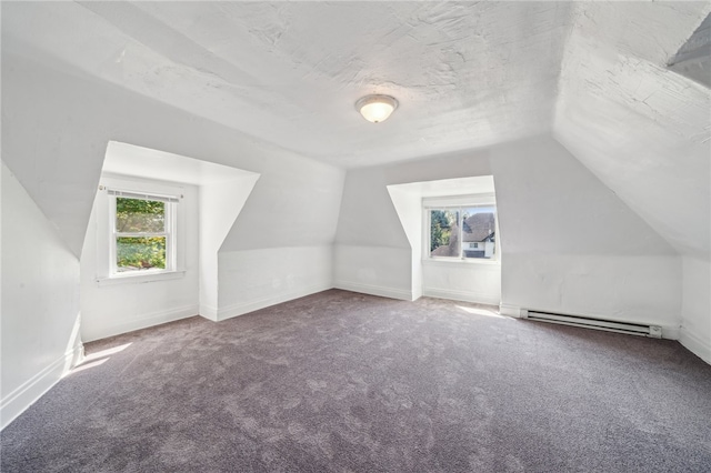 additional living space featuring a baseboard heating unit, carpet floors, and lofted ceiling