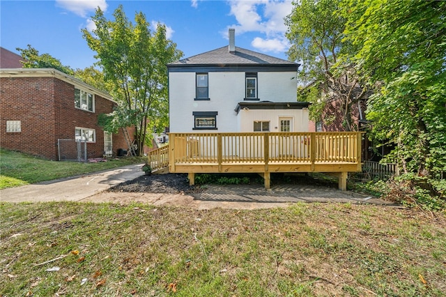 back of house with a wooden deck and a yard