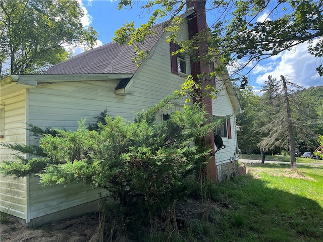 view of side of home with a yard