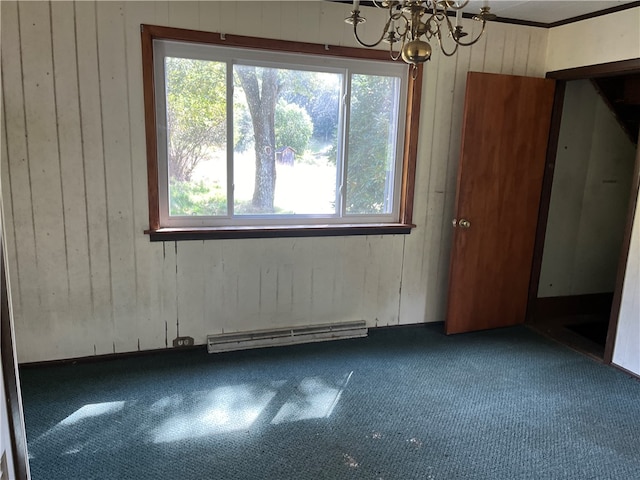 interior space featuring a healthy amount of sunlight, baseboard heating, an inviting chandelier, and wooden walls