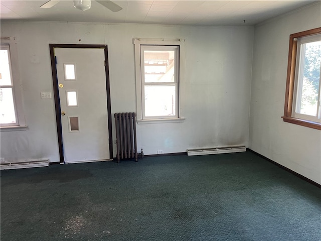 foyer with baseboard heating, ceiling fan, dark colored carpet, and radiator heating unit