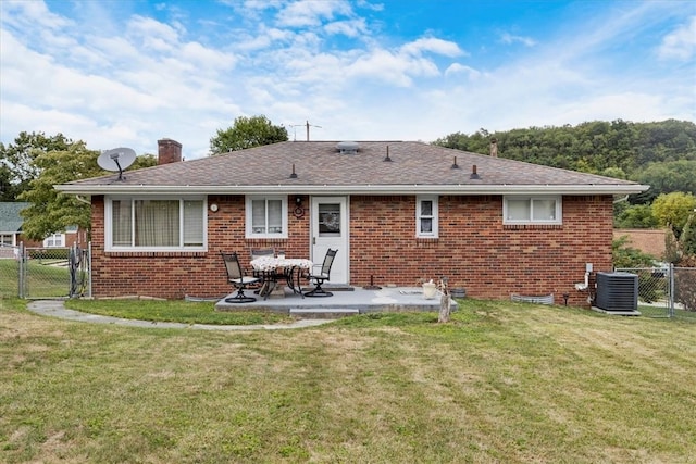 back of property with a yard, a patio area, and central air condition unit