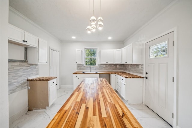 kitchen featuring hanging light fixtures, white cabinetry, and butcher block counters