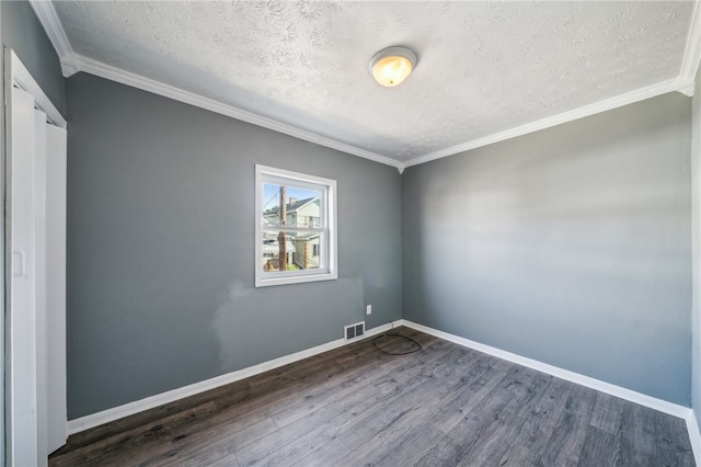 empty room featuring dark hardwood / wood-style floors, ornamental molding, and a textured ceiling