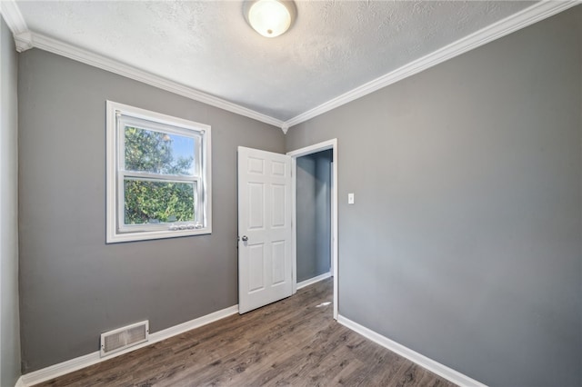 spare room featuring ornamental molding, dark hardwood / wood-style flooring, and a textured ceiling