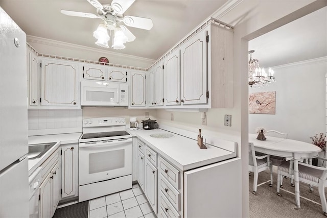 kitchen with ceiling fan with notable chandelier, white appliances, light tile patterned floors, ornamental molding, and white cabinets