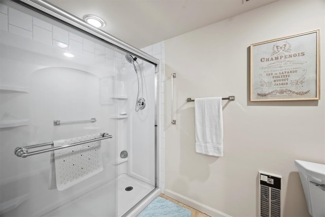 bathroom featuring toilet, walk in shower, and heating unit