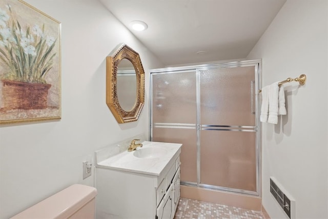 bathroom featuring vanity, toilet, an enclosed shower, and tile patterned floors