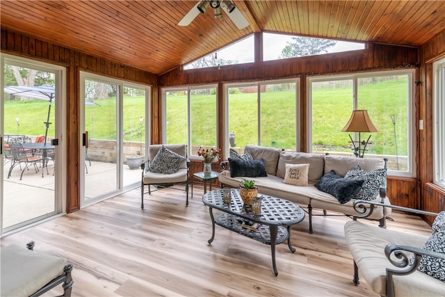 living room with vaulted ceiling, light hardwood / wood-style flooring, wood walls, and ceiling fan