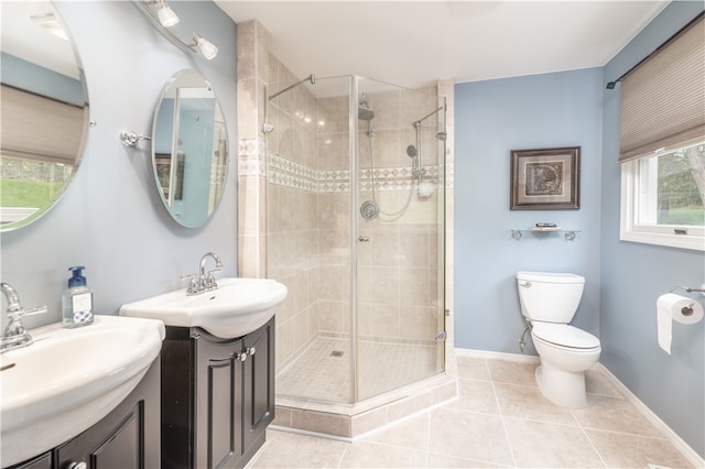 bathroom with tile patterned flooring, vanity, toilet, and walk in shower