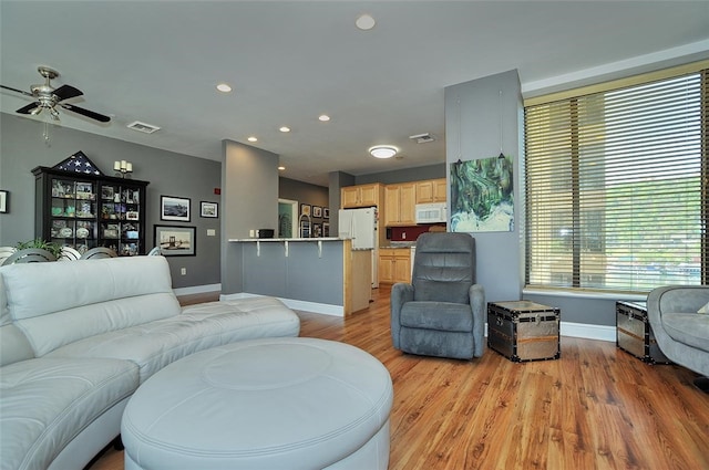 living room featuring ceiling fan and light hardwood / wood-style floors