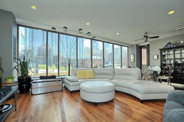 living room featuring wood-type flooring, floor to ceiling windows, and ceiling fan