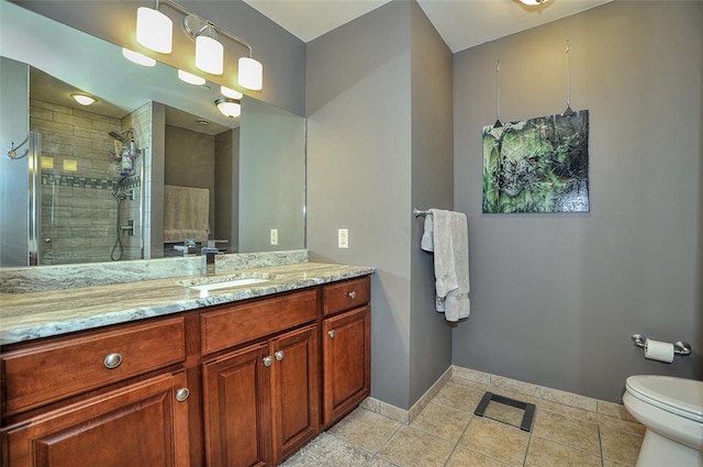 bathroom with tile patterned flooring, vanity, toilet, and an enclosed shower