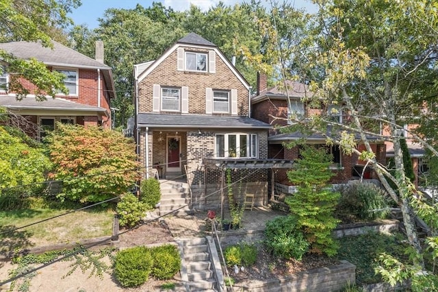 view of front facade with brick siding and stairs