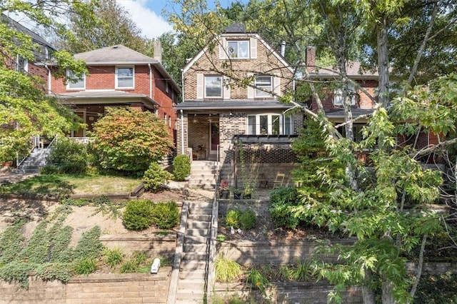 view of front of house with brick siding and stairs