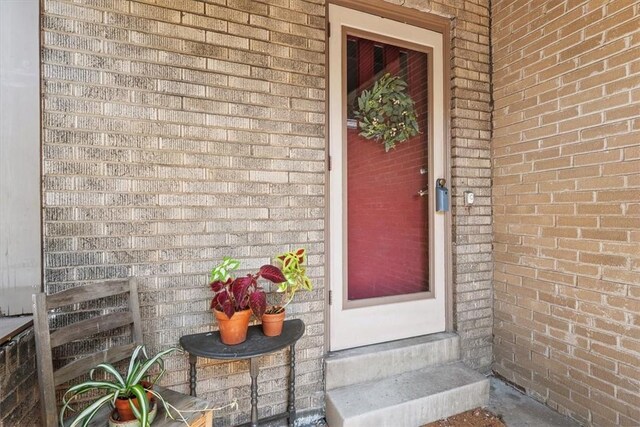 doorway to property with brick siding