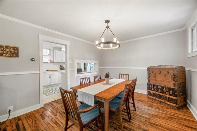 dining room featuring an inviting chandelier, light hardwood / wood-style floors, and ornamental molding