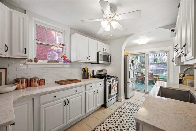 kitchen with stainless steel appliances, sink, ceiling fan, and white cabinets