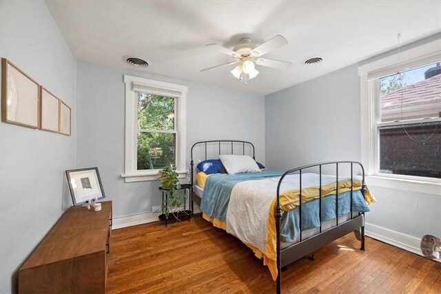 bedroom featuring multiple windows, ceiling fan, and wood-type flooring