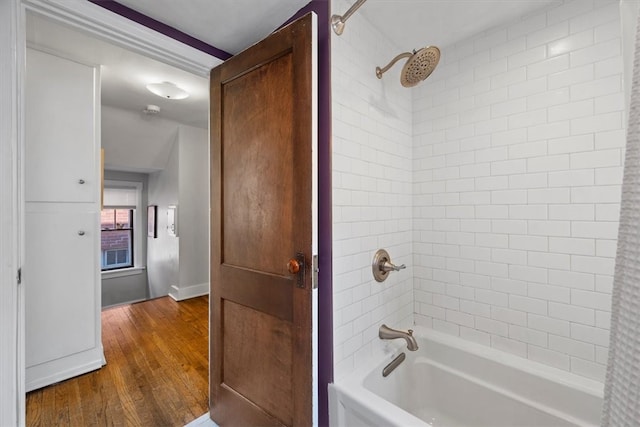 bathroom featuring tiled shower / bath combo and hardwood / wood-style flooring