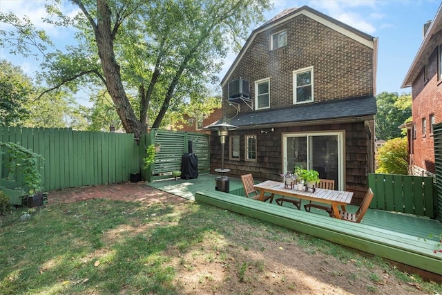 rear view of house with a wooden deck and a yard