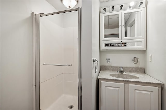 bathroom with a shower with shower door and vanity