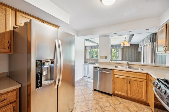 kitchen with stainless steel appliances, light tile patterned flooring, and sink