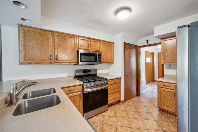 kitchen featuring appliances with stainless steel finishes, light tile patterned flooring, and sink