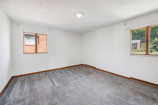 carpeted empty room with a baseboard radiator