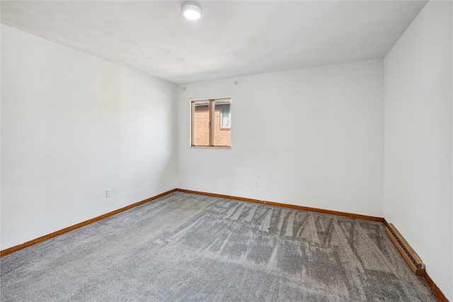 carpeted empty room featuring a baseboard heating unit