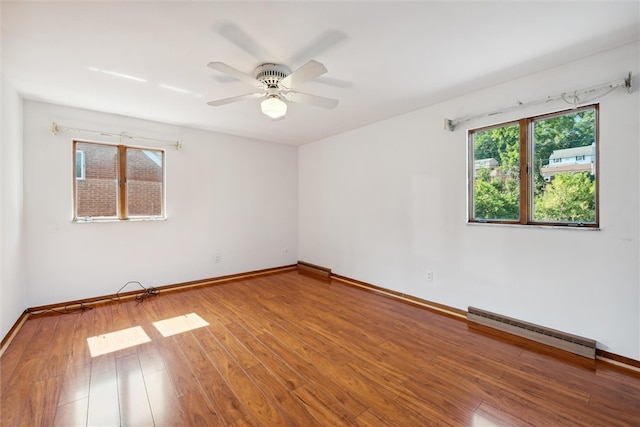 empty room featuring baseboard heating, hardwood / wood-style floors, and ceiling fan