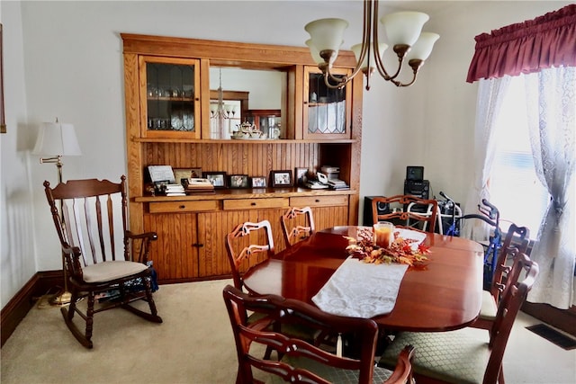 carpeted dining area with a notable chandelier