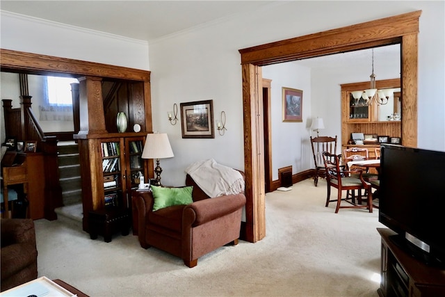 living room featuring ornamental molding, a chandelier, and light colored carpet