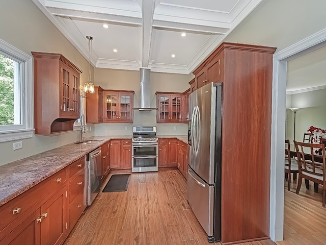 kitchen with decorative light fixtures, stainless steel appliances, light hardwood / wood-style floors, wall chimney range hood, and ornamental molding