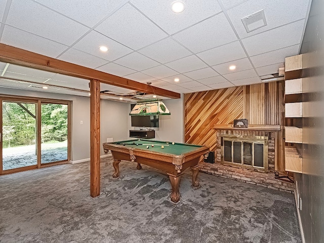 rec room featuring carpet flooring, wood walls, pool table, and a brick fireplace