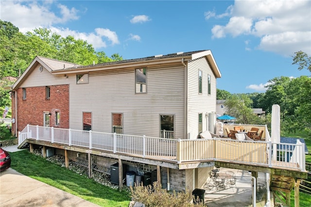 rear view of house featuring a yard and a wooden deck