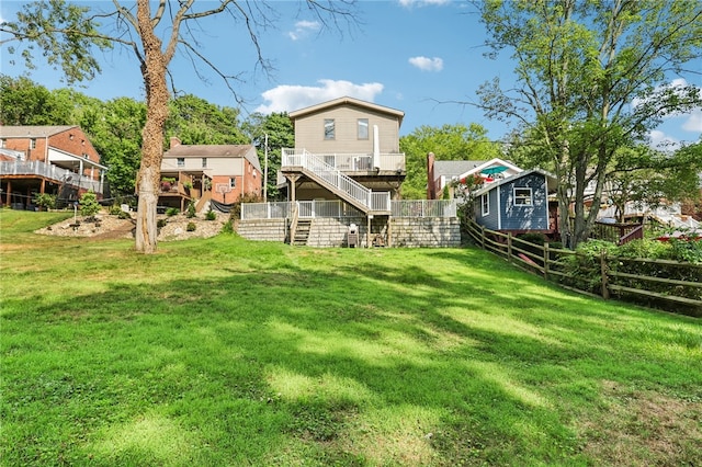 back of property featuring a wooden deck and a lawn